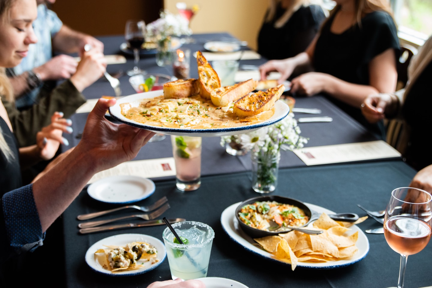 Private Dining Reservations at Jack Allen's Kitchen - People Passing Out Food Between Them